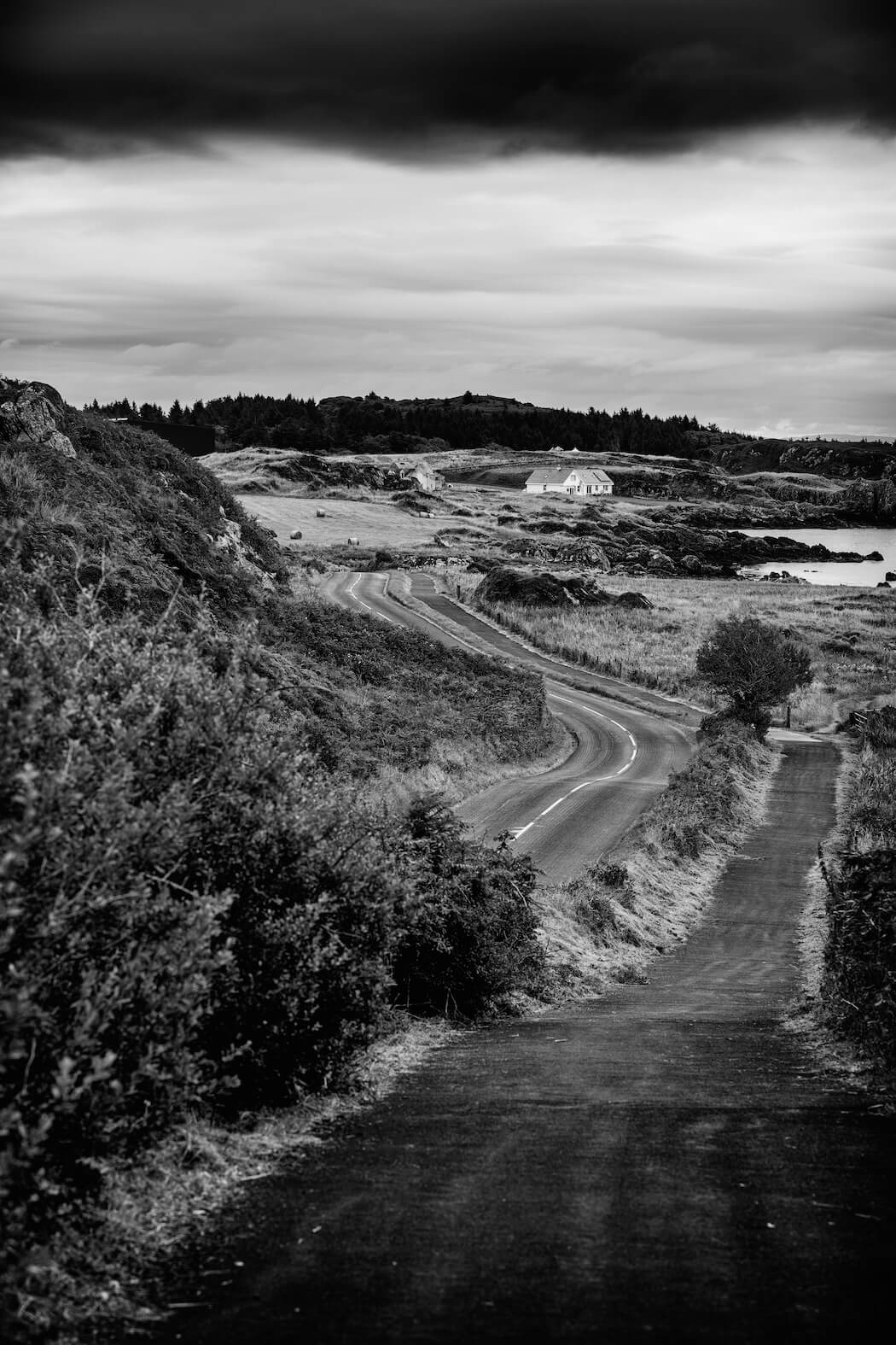 Fine art black and white landscape photograph of a road on Islay, Scotland, creating a striking perspective through the scenery