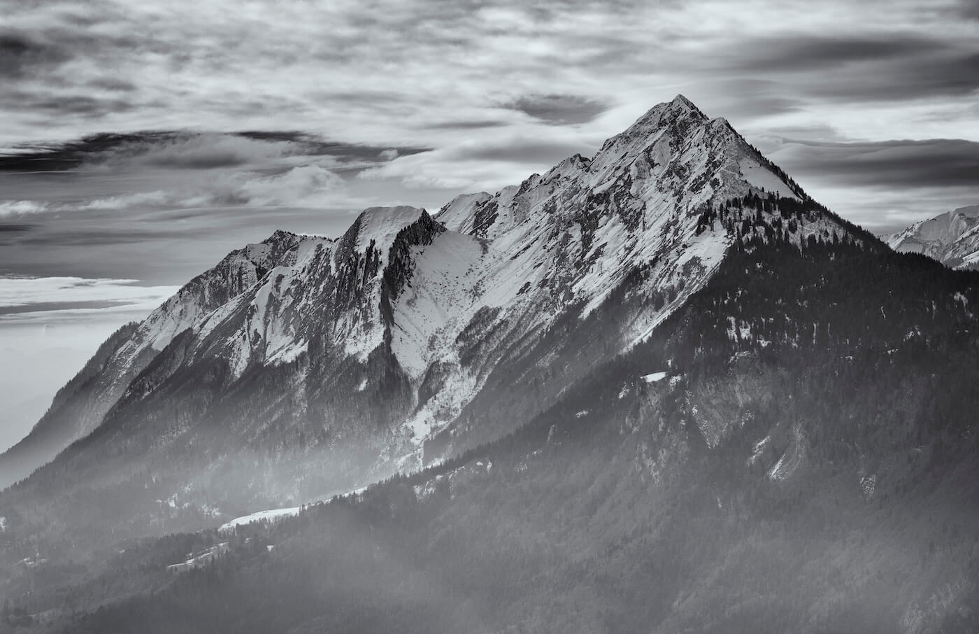 Fine art black and white photograph of a majestic snowy mountain peak in winter