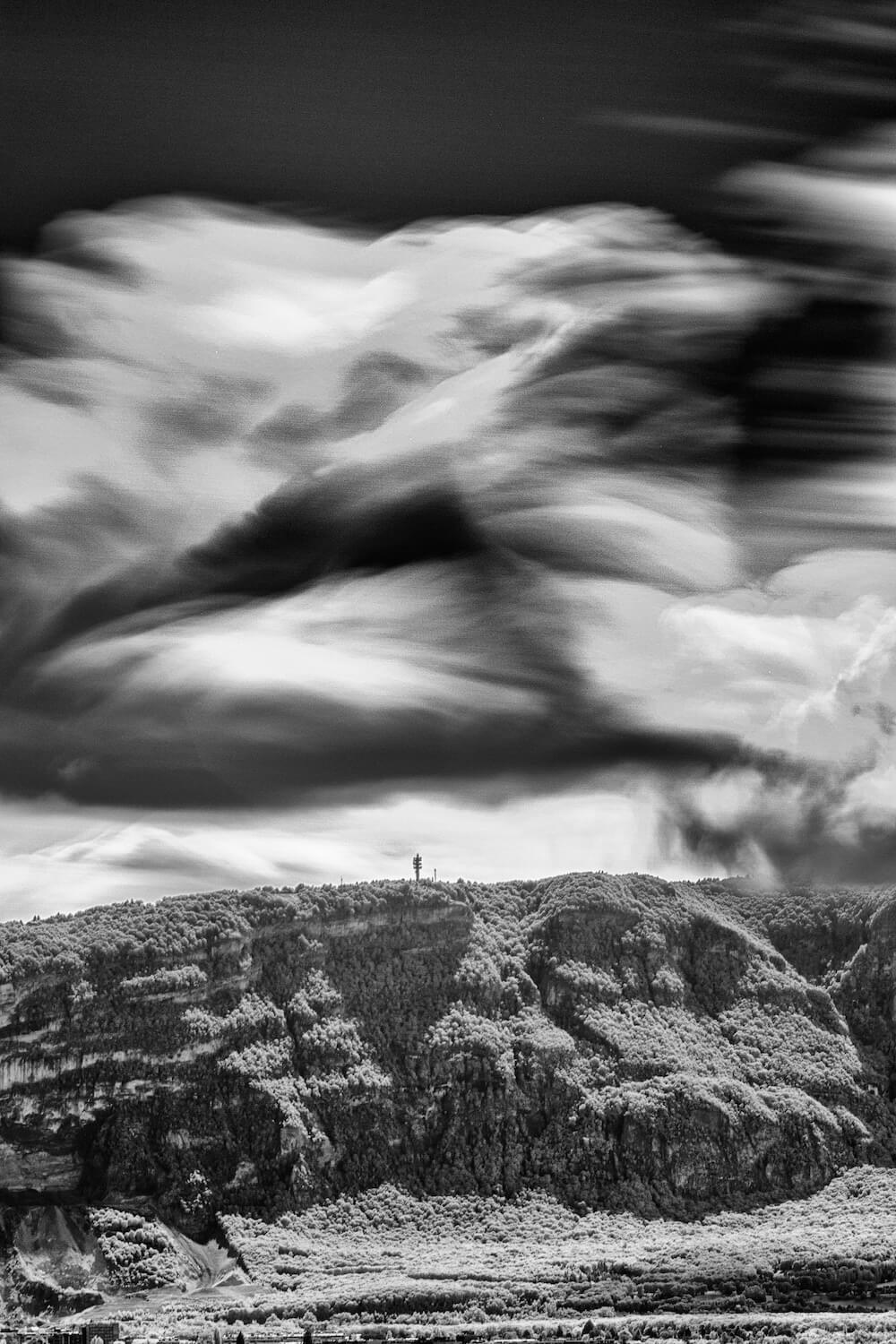 Infrared fine-art landscape of the Salève mountain seen from Geneva with silky clouds drifting above