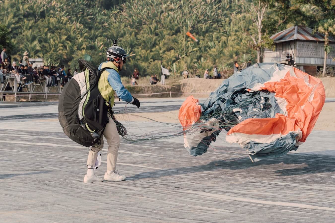 Paragliding pilot in Mizoram just after landing, with the wing folding to the ground
