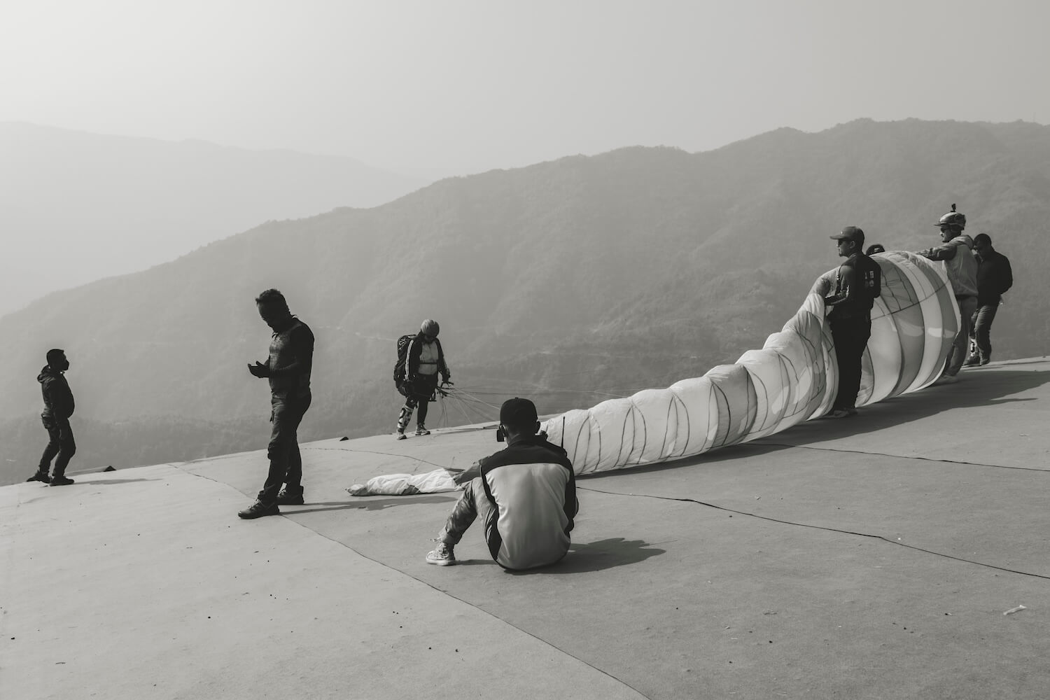 Paragliding pilot preparing the wing before takeoff in Mizoram, India