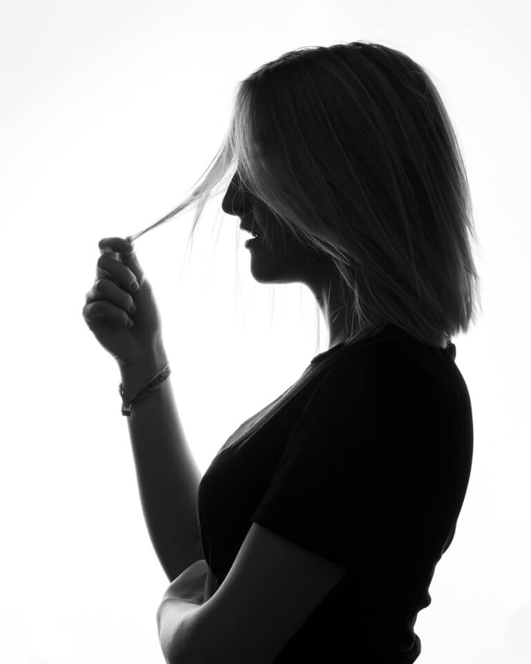 Studio portrait silhouette of a woman in Geneva, photographed against a glowing softbox light