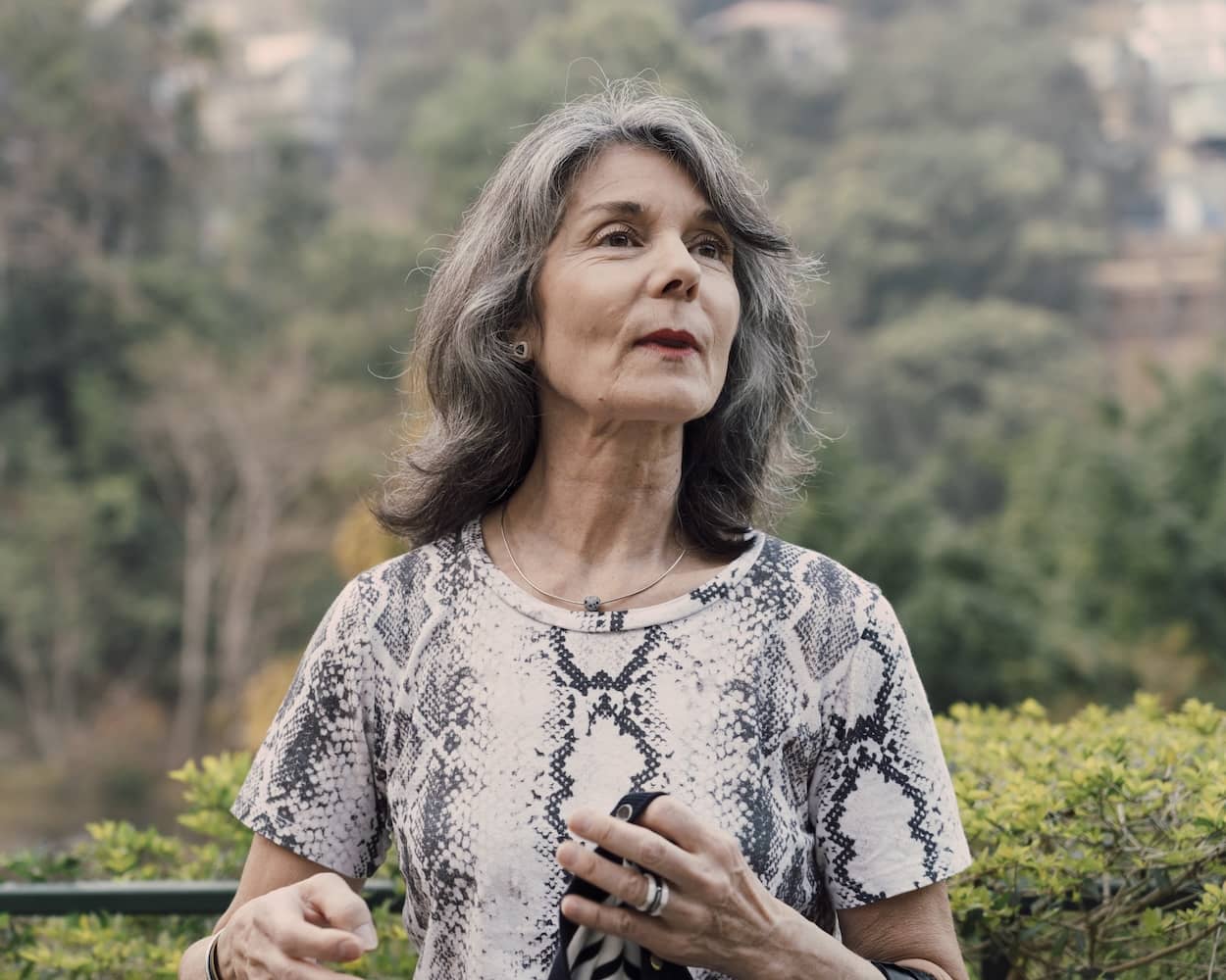Candid cinematic portrait of a woman looking upward with a contemplative expression in a lush green natural environment that one can find in Aizawl, Mizoram.