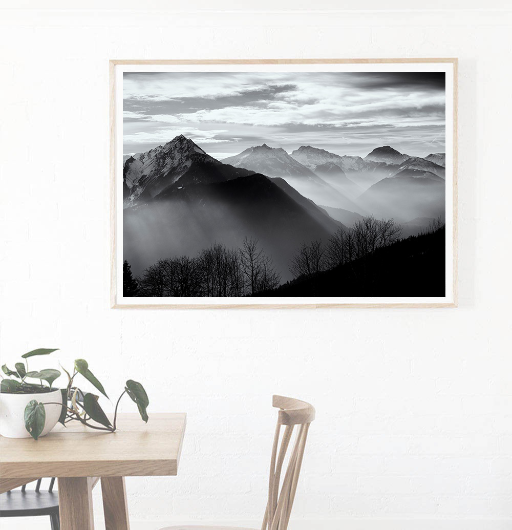 Fine art black and white photograph of mountains with ethereal mist drifting through the valley